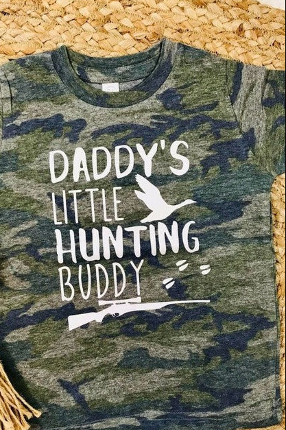 A vintage camouflage colored t-shirt with the text 'Daddy's Little Hunting Buddy' printed on the front.