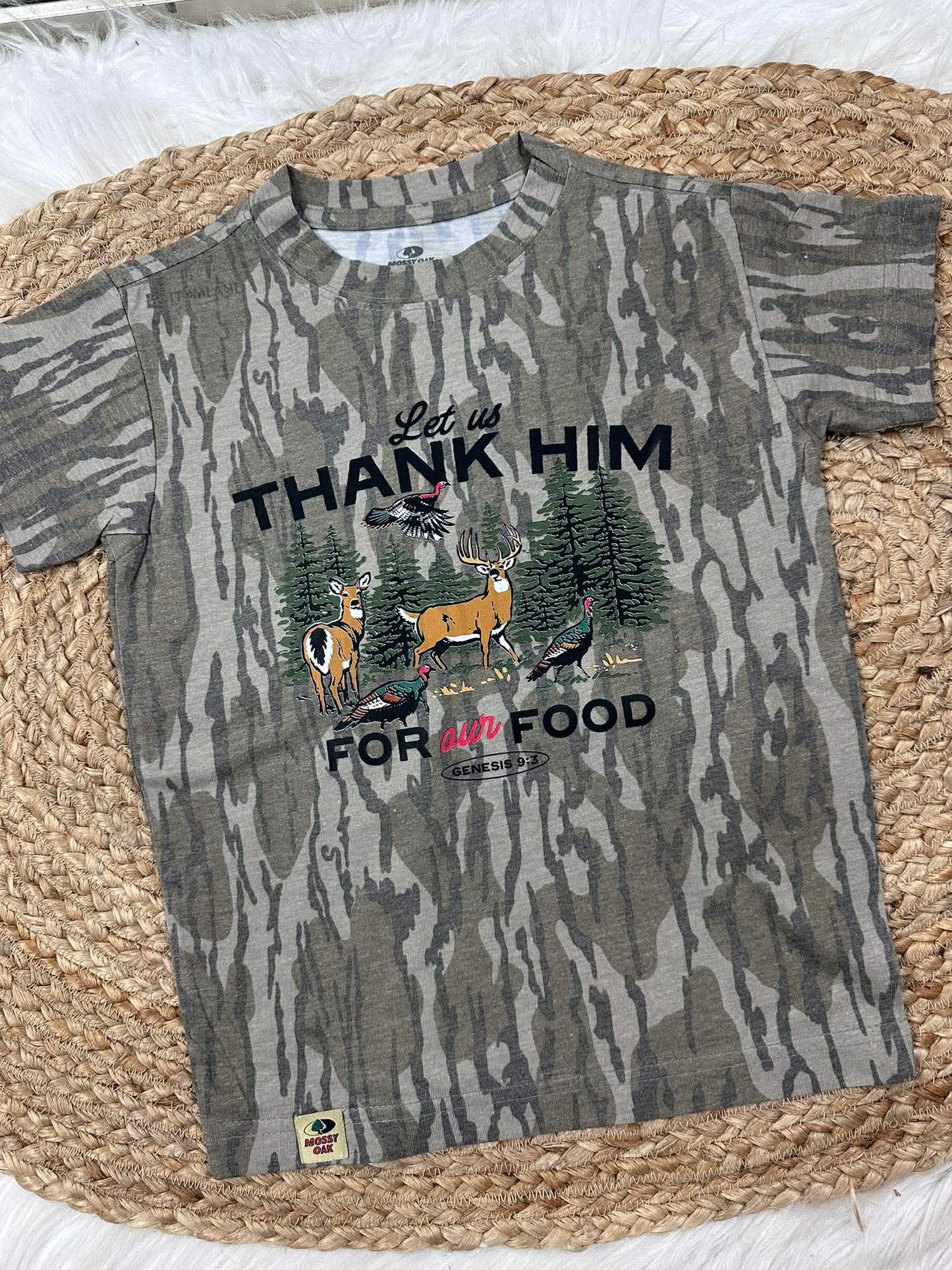 Camouflage t-shirt with hunting-themed design on a woven mat