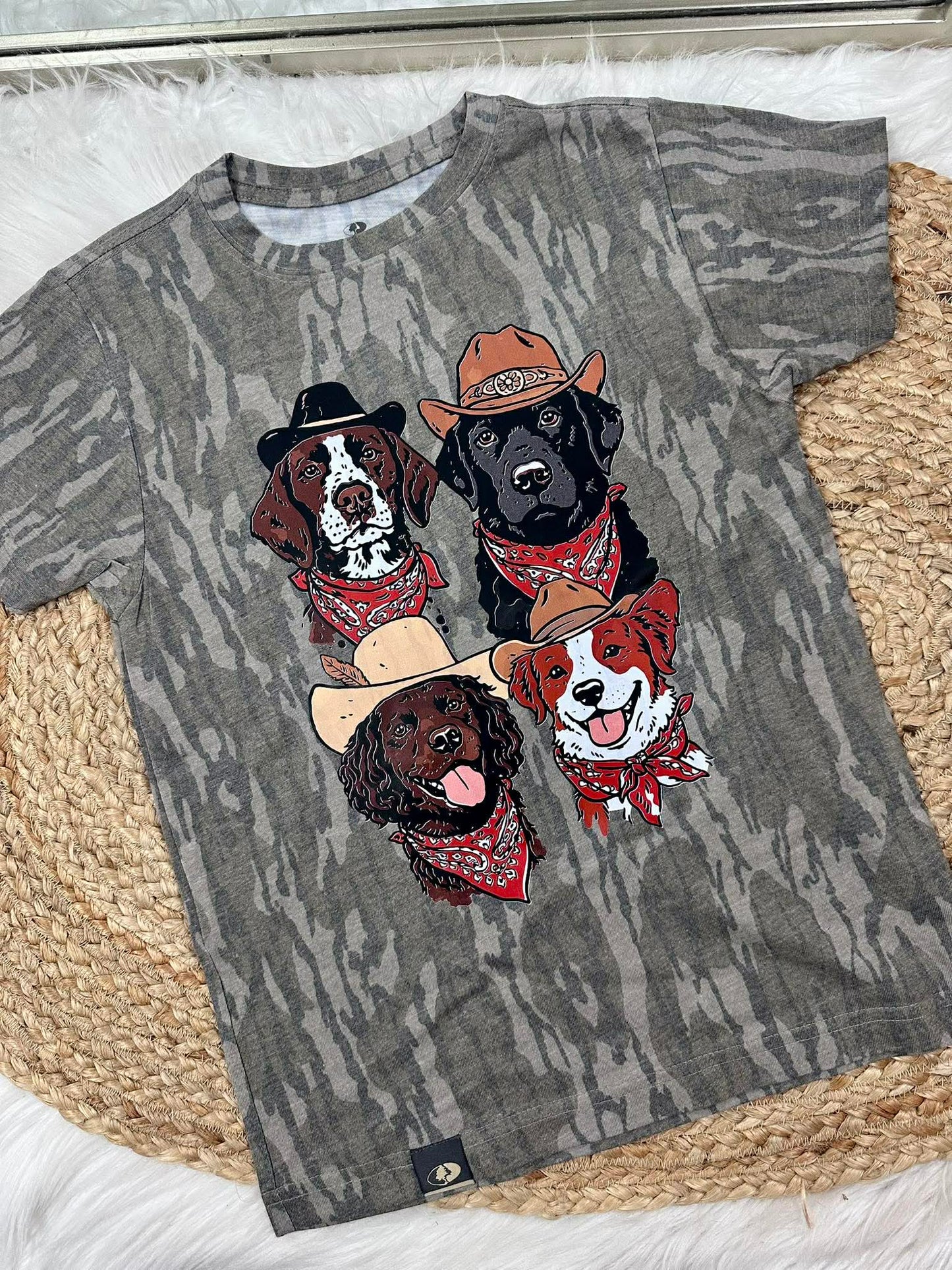 Gray t-shirt with illustrations of dogs wearing hats and bandanas on a textured surface.