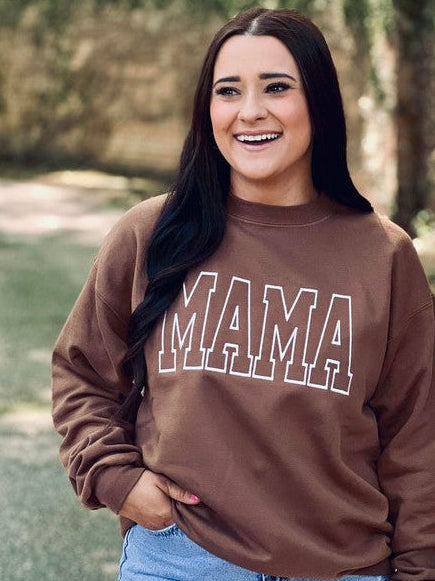 A person wearing an embroidered sweatshirt with the word 'mama' on the front, paired with denim shorts.