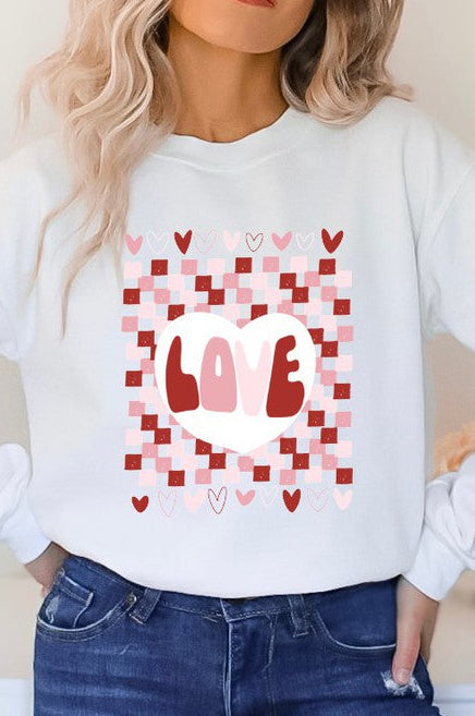 A female model wearing a white checkered pattern t-shirt with a heart and the word 'love' on the front.