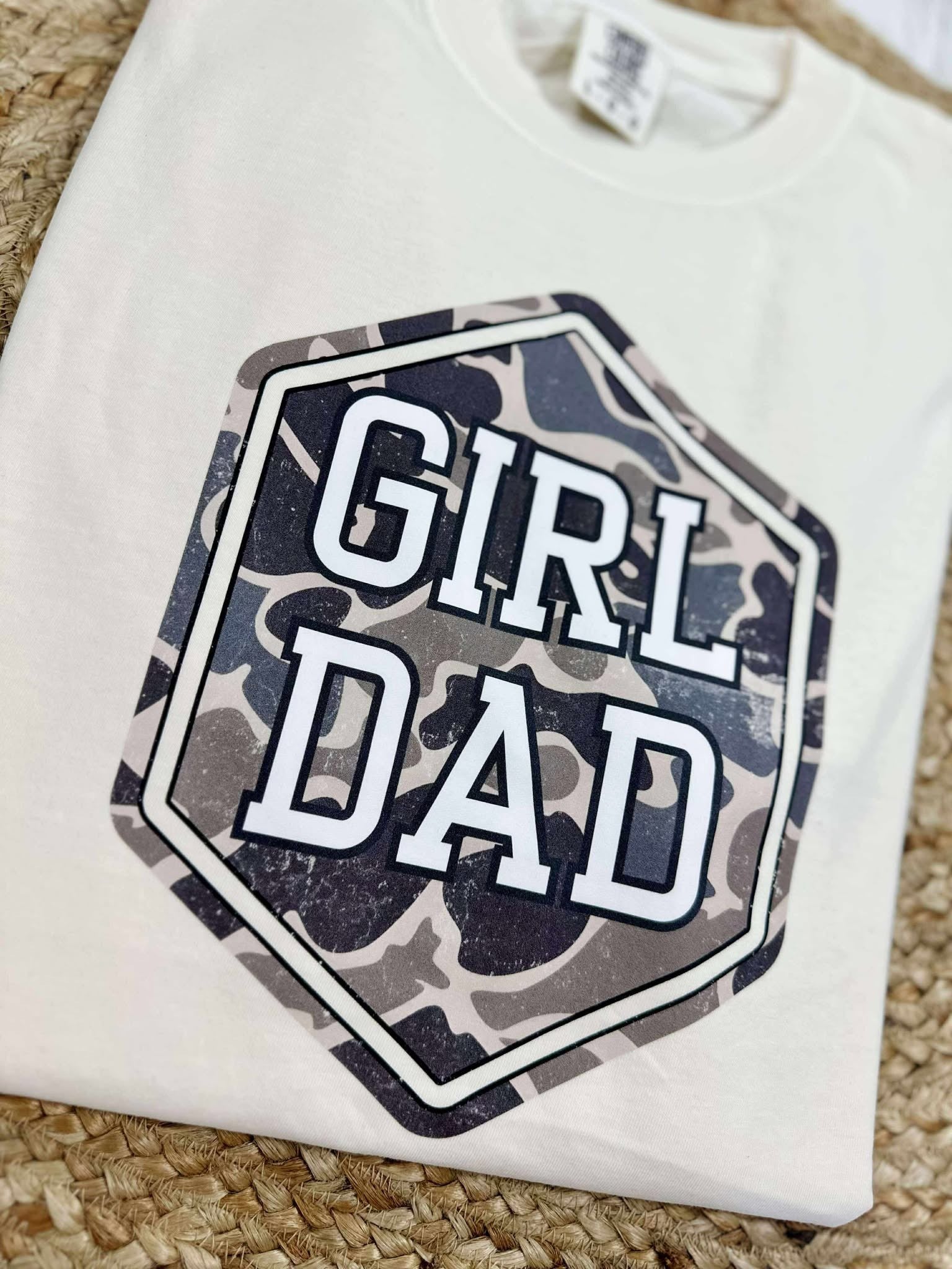 White sweatshirt with 'Girl Dad' graphic on a textured surface
