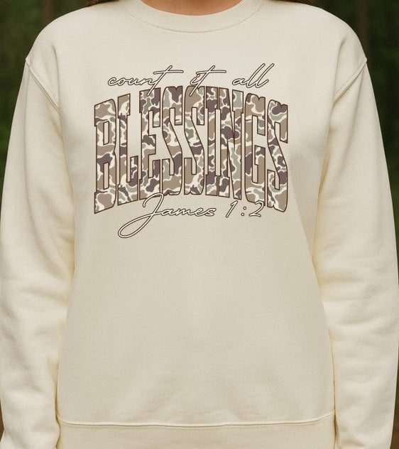 White sweatshirt with Count it all blessings james 1:2 text camo design against a natural background