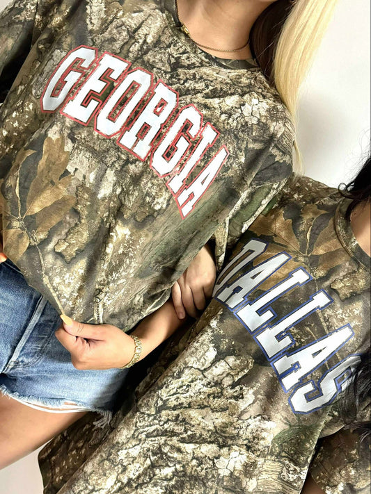 Two people wearing Real Tree camouflage t-shirts with 'Georgia' and 'Dallas' text.