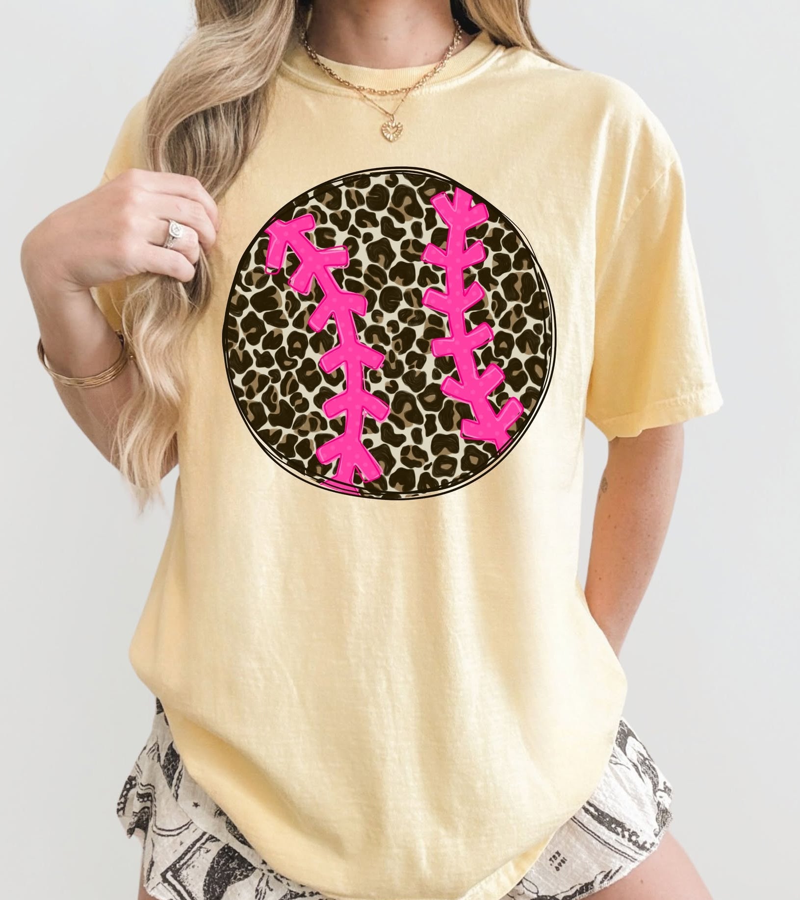Person wearing a yellow t-shirt with a pink and black Leopard design on a white background