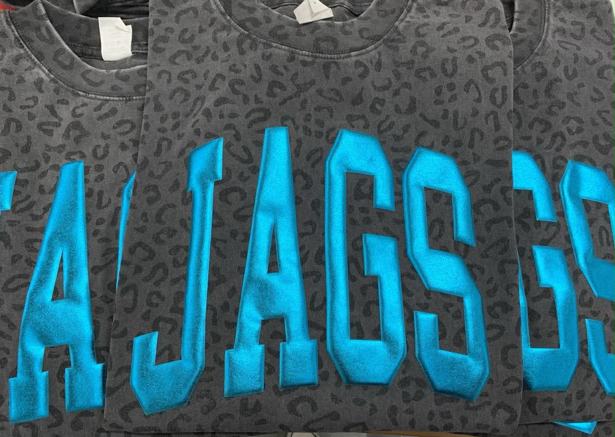 Gray sweatshirt with blue 'JAGS' Puff vinyl on a black leopard tee background