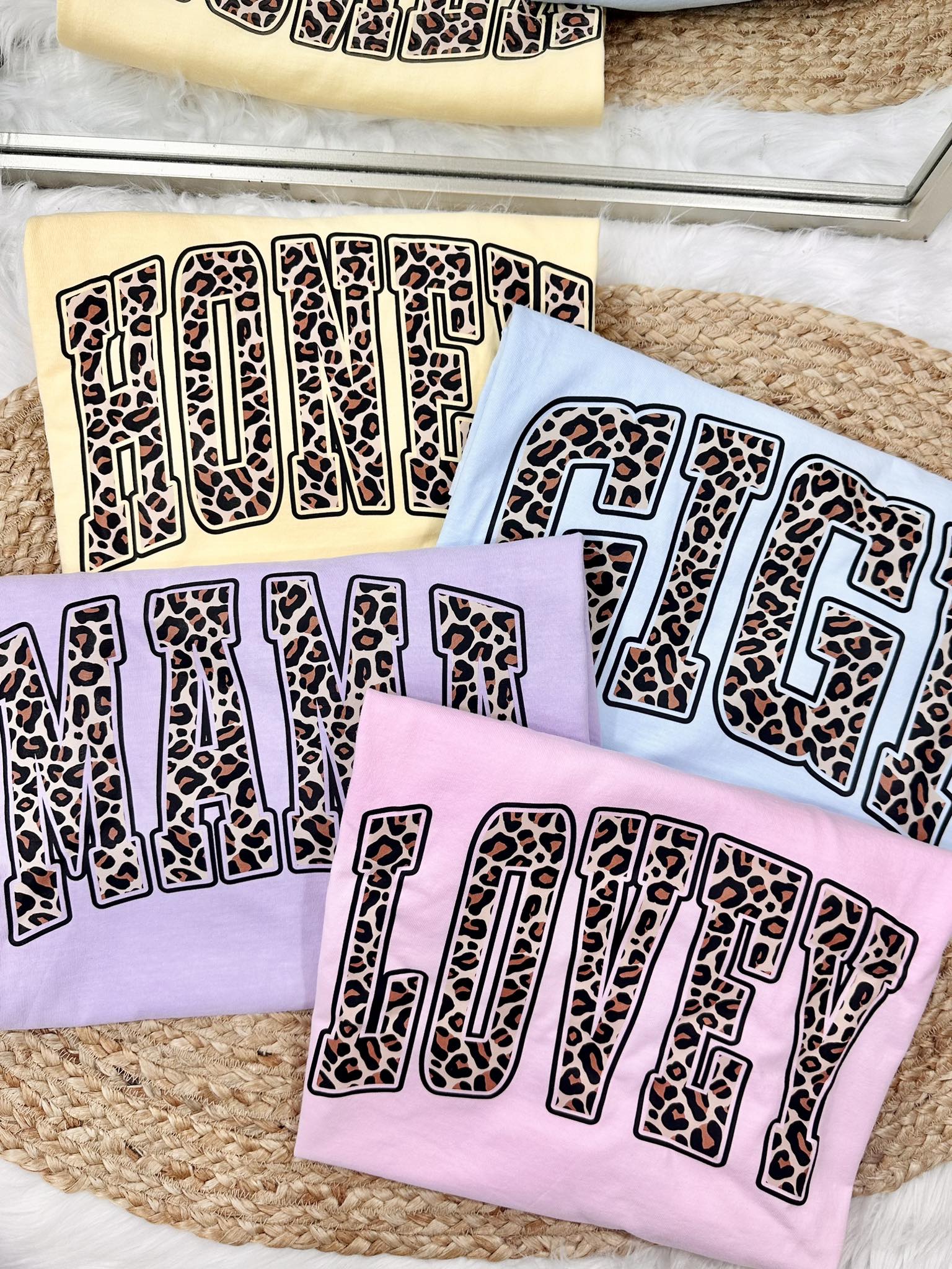 Set of towels with leopard print text on a textured surface