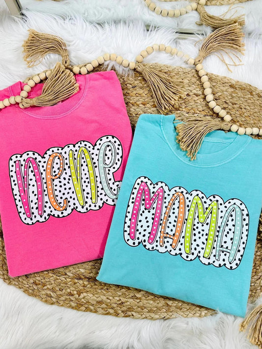 Two colorful t-shirts with 'New Mom' text on a textured surface.