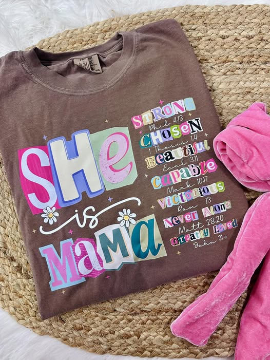 Brown t-shirt with colorful text design on a woven surface