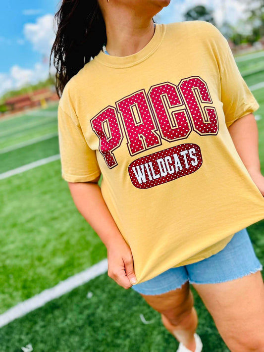 Person wearing a yellow t-shirt with 'PRCC Wildcats' text on a sports field.