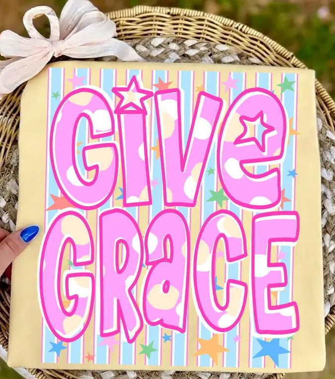 Decorative sign with 'Give Grace' text on a striped background, held over a woven basket.