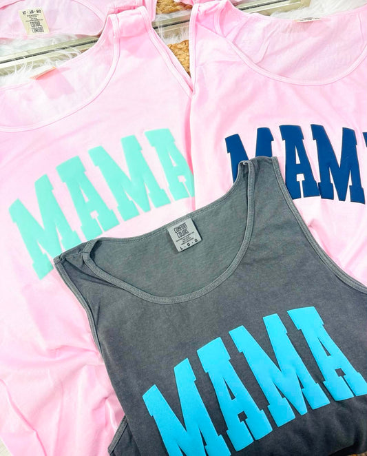 Three tank tops with 'MAMA' text in different colors on a pink background.