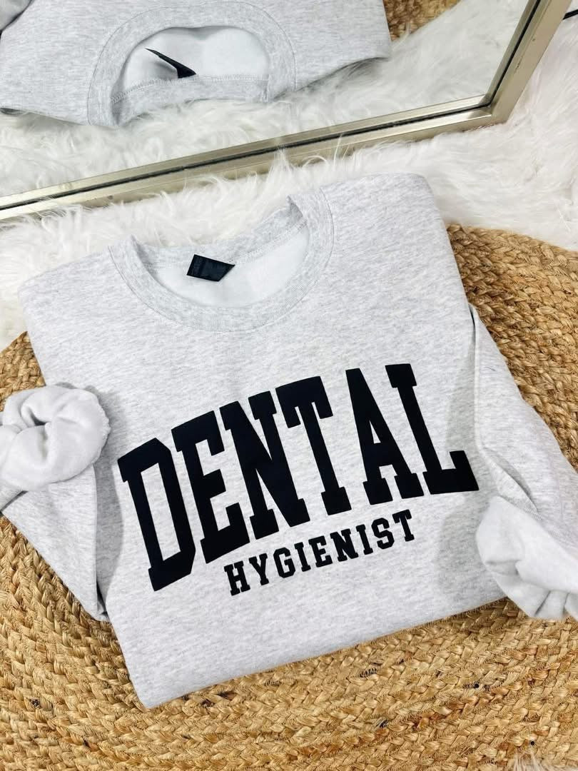 Gray sweatshirt with 'DENTAL HYGIENIST' text on a textured surface