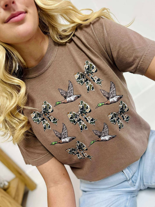 Woman wearing a Espresso t-shirt with duck bow designs on a white background