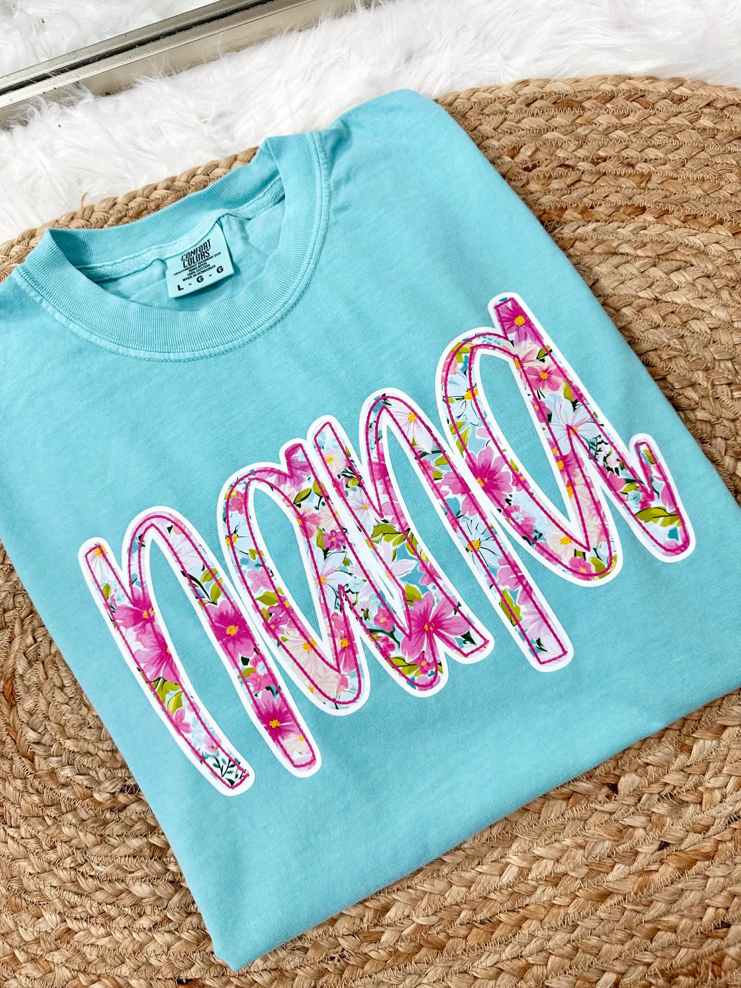 Chalky Mint Light blue tee sweatshirt with floral graphic 'nana' dtf print text on a textured surface