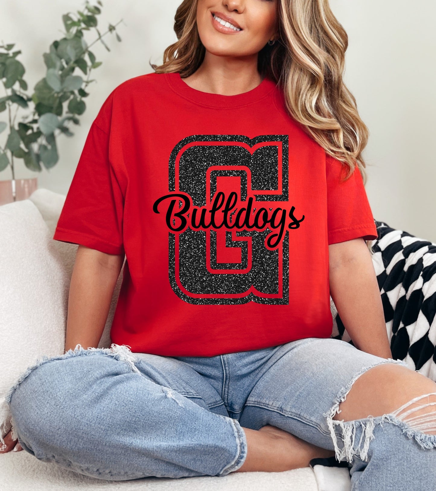 Person wearing a red 'Bulldogs' t-shirt sitting on a couch.